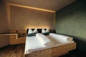 a bedroom with a large white bed with pillows at Obertimpflerhof Wohnung Rosi in Verano