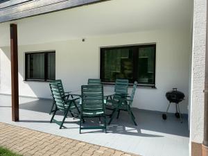 a group of green chairs sitting on a patio at Ferienwohnung Ödbach mit Terrasse in Konzell