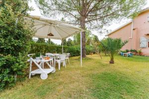 a table and chairs under an umbrella in a yard at Soberania in Pula