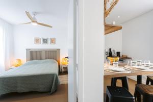 a bedroom with a bed and a dining table at Les iles, Rivedoux Beach House in Rivedoux-Plage