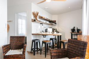 a kitchen with a bar and stools in a room at Les iles, Rivedoux Beach House in Rivedoux-Plage