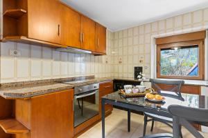 a kitchen with wooden cabinets and a table with a bowl of fruit at El Bosque in Candamin