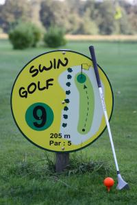 a sign for a golf course with a ball and a bat at Ferienwohnung Haarkotten in Steinfurt +2 photos