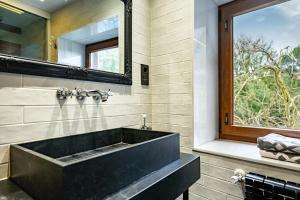 a bathroom with a black sink and a mirror at El Bosque in Candamin +15 photos