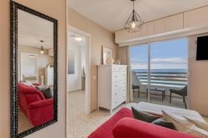 a living room with a red couch and a mirror at Vv Tamara Sunset Suite in Tacoronte
