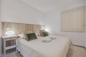 a bedroom with a large white bed with green pillows at Vv Tamara Sunset Suite in Tacoronte