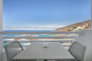 a table and chairs on a balcony with the ocean at Vv Tamara Sunset Suite in Tacoronte