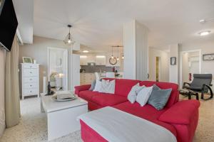 a living room with a red couch and a kitchen at Vv Tamara Sunset Suite in Tacoronte