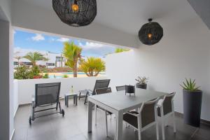 a dining room with a white table and chairs at vv Infinity Casilla in La Oliva