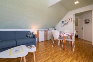 a living room with a blue couch and a table at Le Sea Bird parking piscine été in Arzon