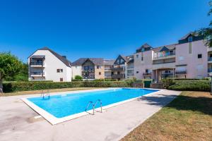 a swimming pool in front of a apartment complex at Le Sea Bird parking piscine été in Arzon