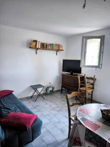ein Wohnzimmer mit Sofa und Schreibtisch in der Unterkunft Studio Bas Verdon in Allemagne-en-Provence