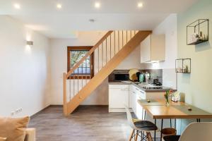 a kitchen with white cabinets and a wooden staircase at Ferienhaus Landliebe in Ötisheim