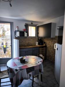 eine Küche mit einem Tisch und eine Küche mit Spüle und Kühlschrank in der Unterkunft Studio Bas Verdon in Allemagne-en-Provence