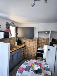 eine kleine Küche mit einem Tisch und einem Kühlschrank in der Unterkunft Studio Bas Verdon in Allemagne-en-Provence + 9 Fotos