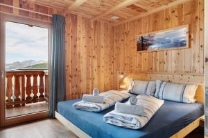 a bedroom with a bed with pillows and a balcony at Almhaus Morgenrast in Sarntal