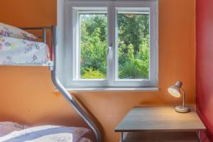 a bedroom with a window and a table with a lamp at Appartement N°3 - Piscine Partagée in Lagorce +14 photos