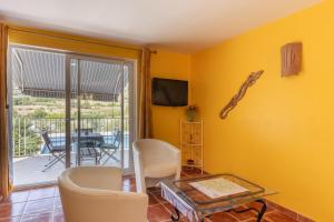 a living room with yellow walls and a table and chairs at Appartement N°3 - Piscine Partagée in Lagorce