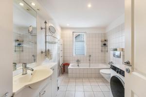 a white bathroom with a tub and a toilet and a sink at Ferienwohnung am Rande Neumünsters in Neumünster +24 photos