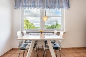 a white dining room table with chairs and a window at Ferienwohnung am Rande Neumünsters in Neumünster