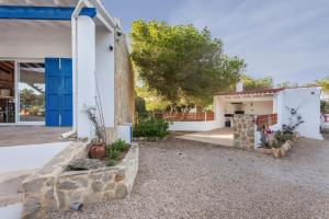 a house with a blue door and a yard at Ses Roques Casa del Sol in Illes Balears