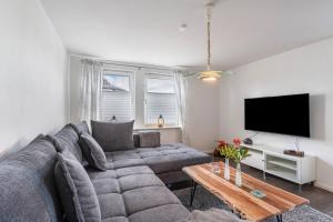 a living room with a couch and a tv at Ferienwohnung am Rande Neumünsters in Neumünster