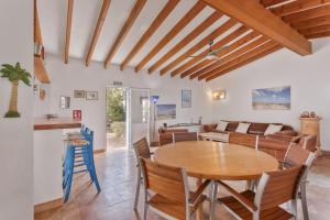a kitchen and living room with a wooden table and chairs at Ses Roques Casa del Sol in Illes Balears