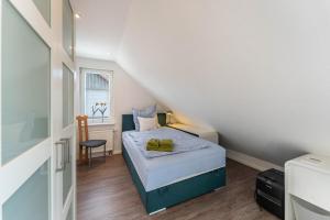 a small bedroom with a bed and a chair at Ferienwohnung am Rande Neumünsters in Neumünster