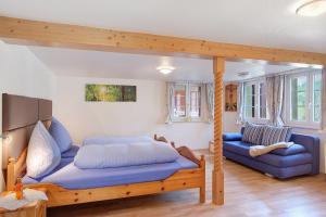 a bedroom with a bed and a blue couch at Alte Schmiede in Feldberg