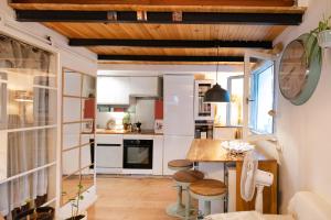 a kitchen with white cabinets and a wooden ceiling at Une escale sur l'océan in Ciboure