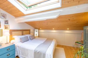 a bedroom with a large bed with a skylight at Une escale sur l'océan in Ciboure