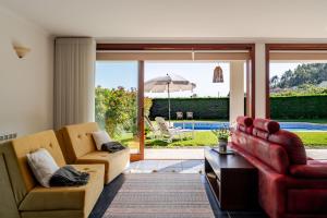 a living room with two couches and an umbrella at Quinta do Outeirinho - Villa Deluxe in Celorico de Basto