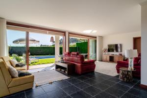 a living room with red furniture and a large window at Quinta do Outeirinho - Villa Deluxe in Celorico de Basto