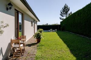 a patio with two chairs and a table and a plant at Quinta do Outeirinho - Villa Deluxe in Celorico de Basto