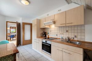 a kitchen with wooden cabinets and a sink at Ferienwohnung Serr in Lauf