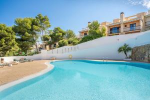 a swimming pool in front of a white wall at Green Park B18 in Son Parc