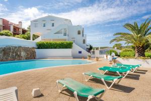 a villa with a swimming pool and lounge chairs at Green Park B18 in Son Parc