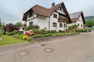 a white house with a brown roof on a street at Ferienwohnung Serr in Lauf