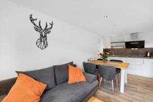 a living room with a couch and a table with a deer on the wall at Fewo Weitblick - Haus Sommerberg in Baiersbronn