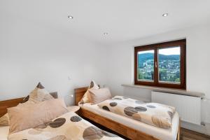 a bedroom with two beds and a window at Fewo Weitblick - Haus Sommerberg in Baiersbronn
