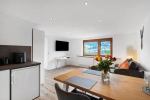 a kitchen and living room with a table and a couch at Fewo Weitblick - Haus Sommerberg in Baiersbronn