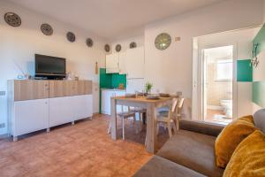 a living room with a table and a kitchen at Appartamento Cerri in Badesi