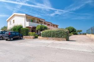 a house with cars parked in a parking lot at Appartamento Cerri in Badesi