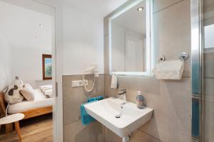 a bathroom with a sink and a mirror and a bed at Fewo Weitblick - Haus Sommerberg in Baiersbronn +18 photos