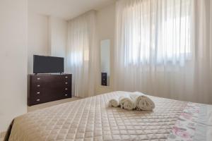 a bedroom with two towels on a bed with a television at Appartamento Leo in Brindisi