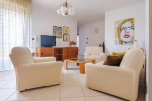 a living room with two chairs and a tv at Appartamento Leo in Brindisi