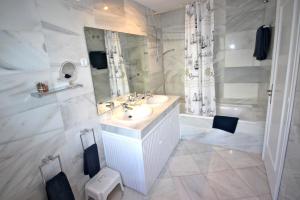 a white bathroom with a sink and a mirror at Deluxe Apartment on the Beach in Marbella +27 photos