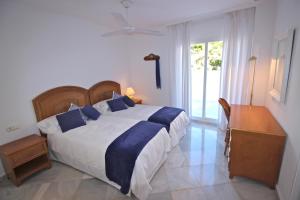 a bedroom with a large bed with blue pillows at Deluxe Apartment on the Beach in Marbella