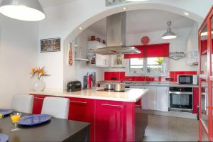 a kitchen with red cabinets and a counter top at Villa Calima Deluxe con Piscina in Tías