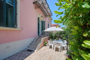 a patio with a table and chairs and a building at Villa Liberty Rosa 1912 in San Vincenzo